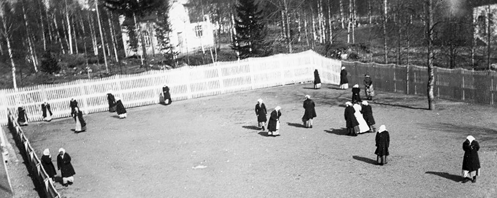 Rastgård med kvinnor på plan omgiven av plank, från 1910-talet.